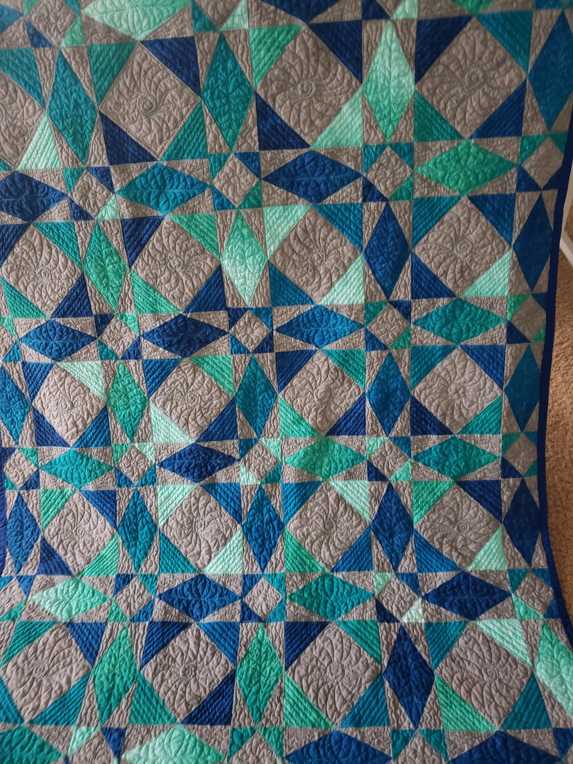 Quilts for Sale/Close-up view of free-motion quilting details on a multi-color handmade Storm At Sea quilt