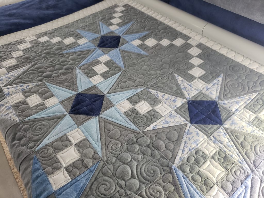 Quilts for Sale/ Blue Hunter’s Star quilt folded neatly showing geometric pattern