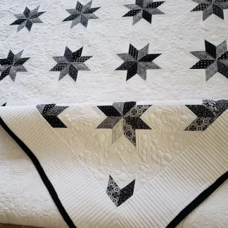 queen size black and white hunters star quilt displayed on bed