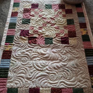 Handmade Quilts for Sale/Side angle of reversible farmhouse quilted décor piece in natural lighting.