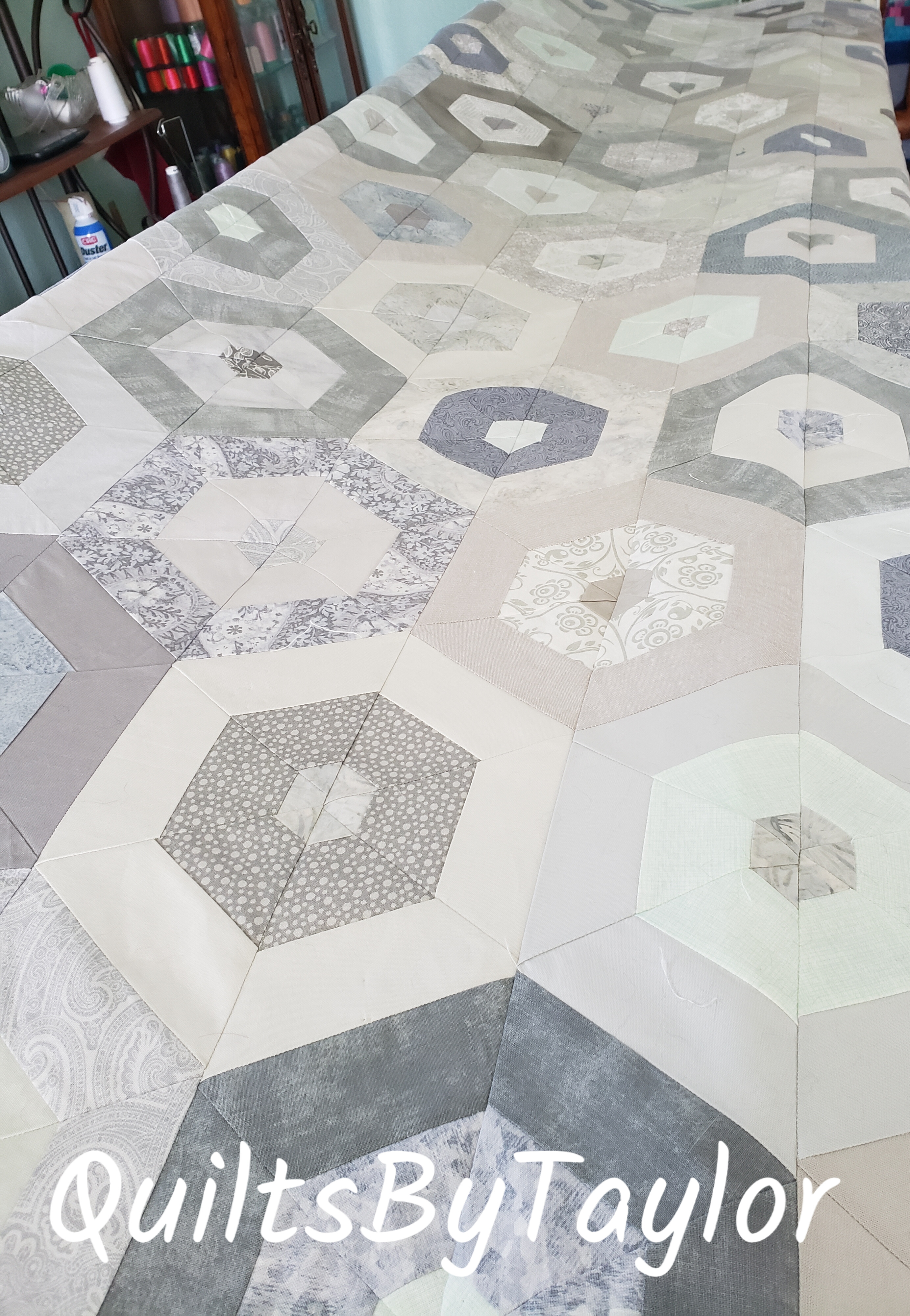 neutral cotton patchwork quilt top laid out before quilting process begins