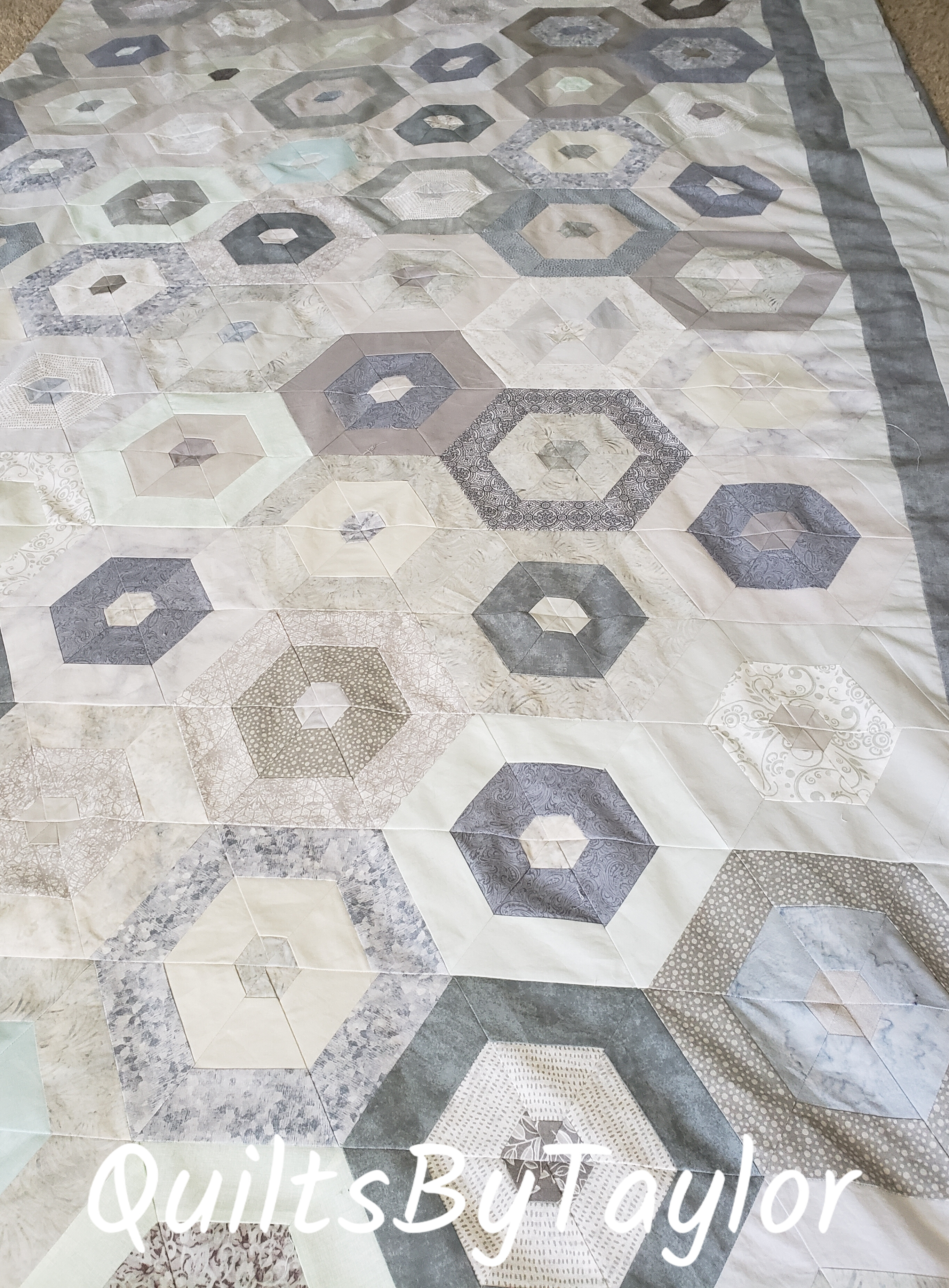 custom handmade quilt top before quilting showing hexagon layout and border design