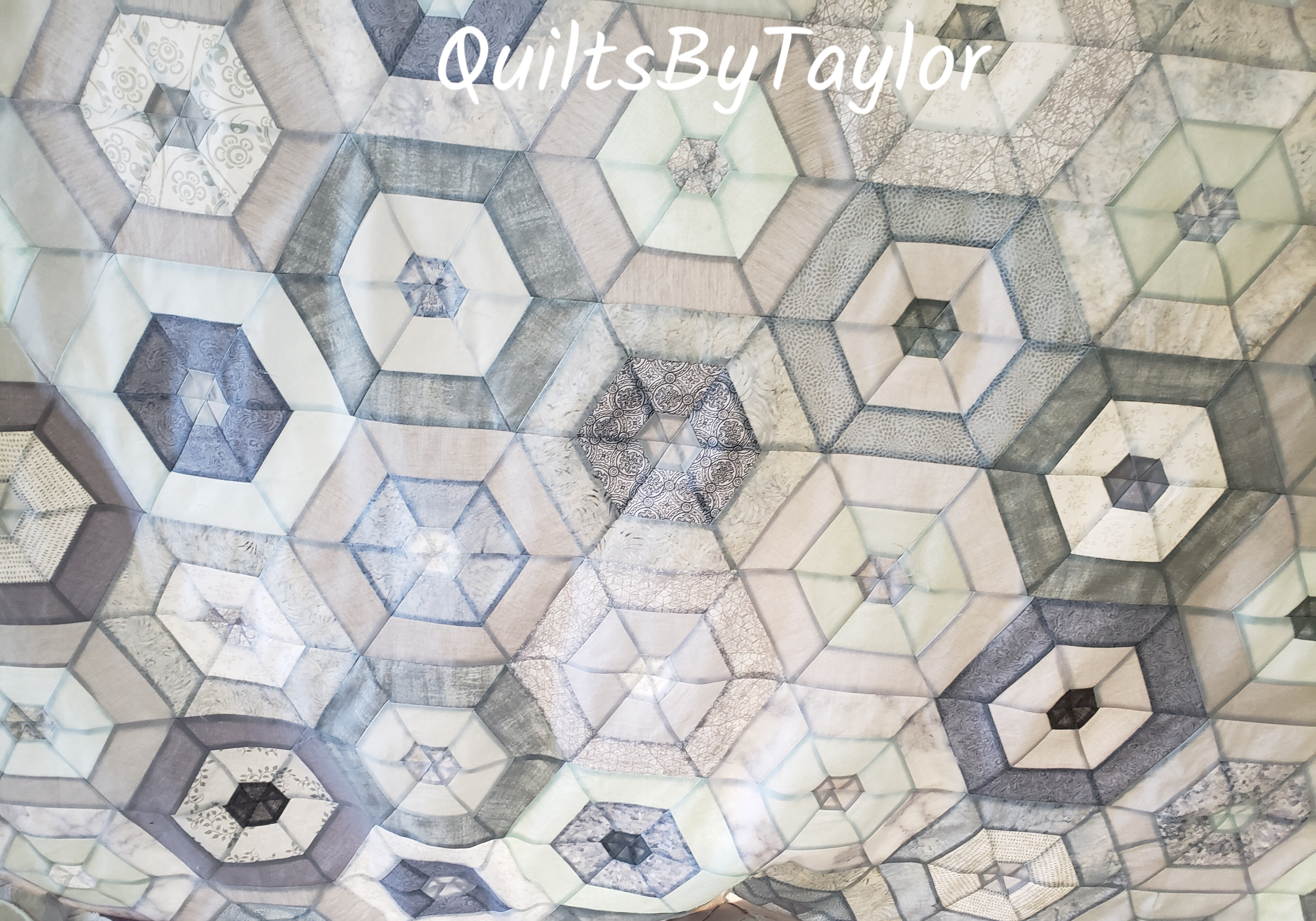 custom neutral cotton quilt loaded onto quilting machine during quilting process