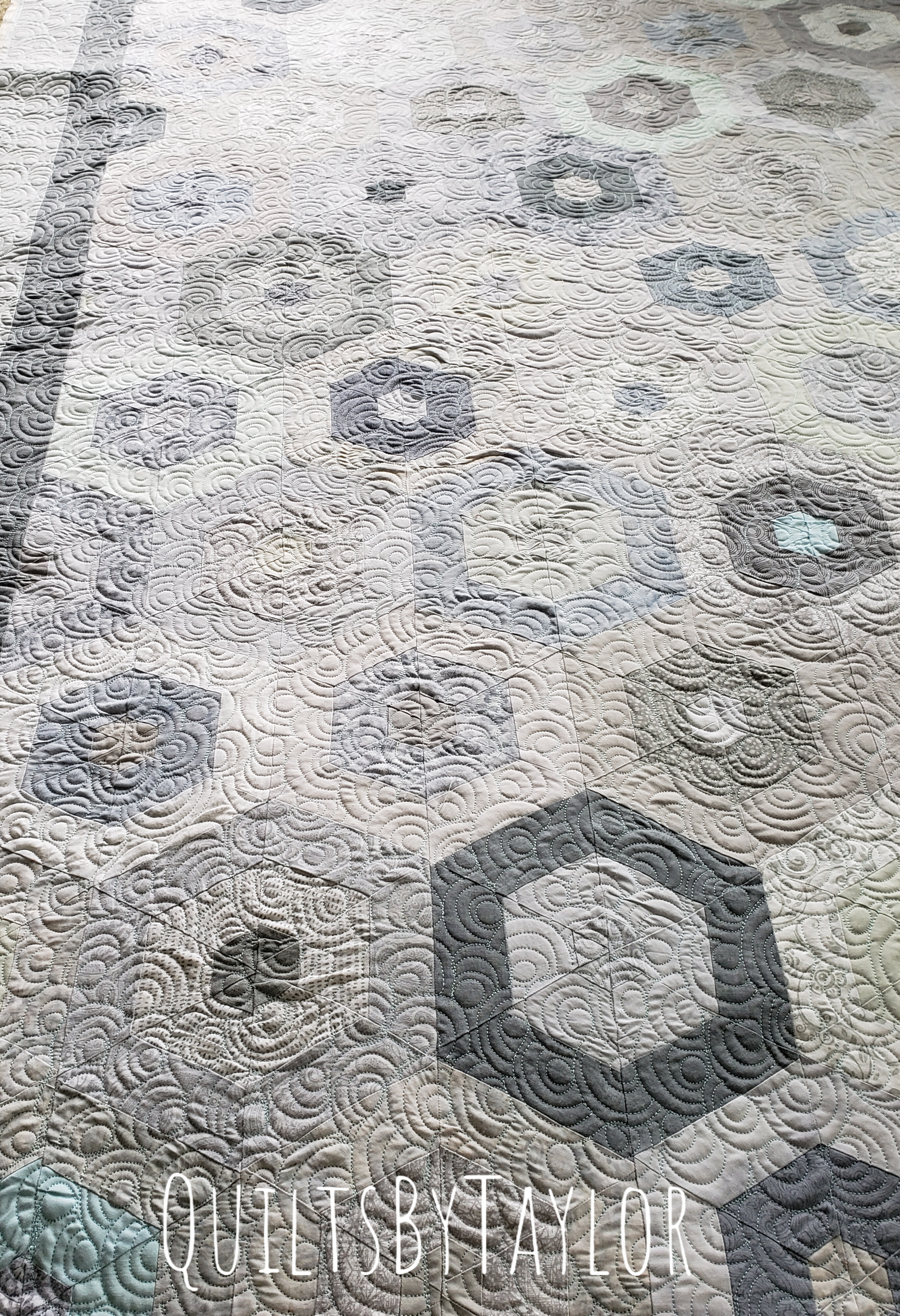 soft neutral patchwork quilt completed with flowing quilting design and heirloom texture