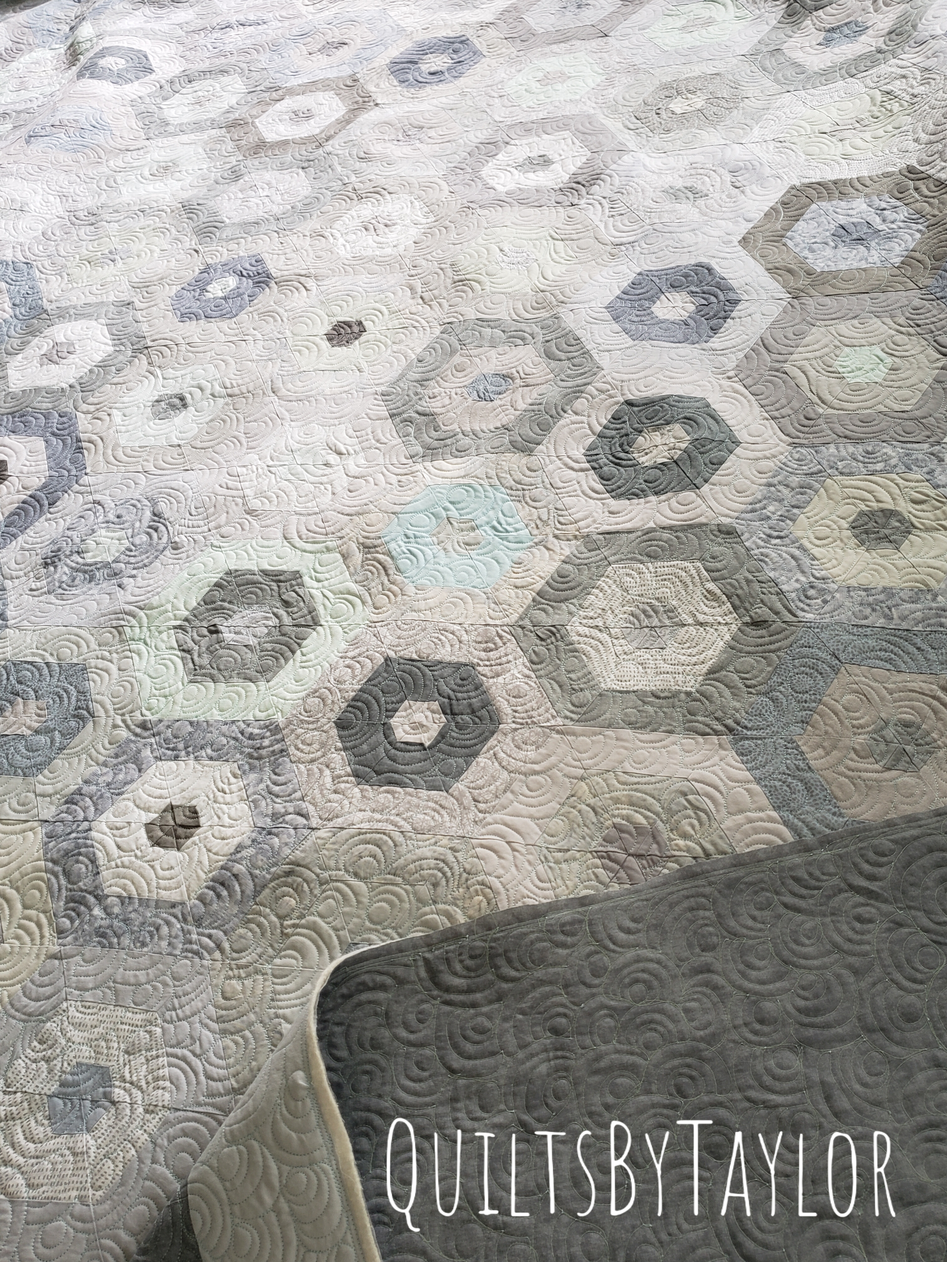soft neutral patchwork quilt completed with flowing quilting design and heirloom texture