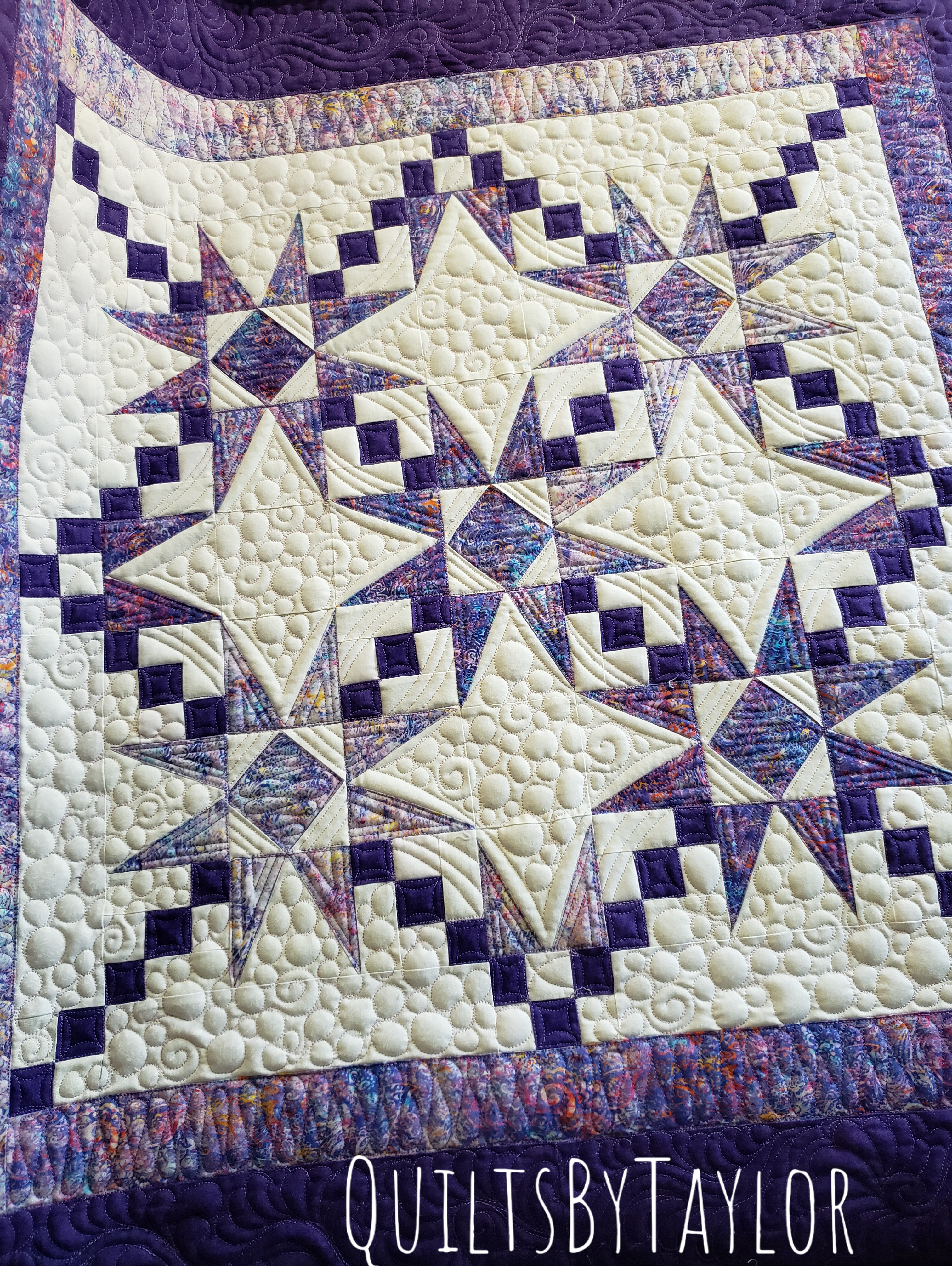 Close-up of machine quilting on a handmade purple quilt with double batting