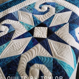 Detailed free-motion quilting across the blue and cream Whimsical Storm At Sea quilt, adding texture and dimension to the pieced design.